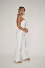 Load image into Gallery viewer, side view angle of white denim jumpsuit paired with beach by matisse daisy cork platform sandals
