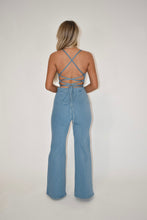 Load image into Gallery viewer, light was denim jumpsuit, open back jumpsuit, criss cross tie back jumpsuit, women&#39;s clothing boutique, online boutique, denim overalls,
