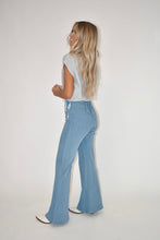Load image into Gallery viewer, light wash denim jumpsuit with stripe tank over it side view angle 
